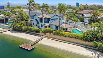 A coastal property with a swimming pool, a dock, and a beachfront.