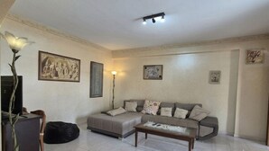 Sala de estar com sofá, mesa de centro e objetos decorativos.