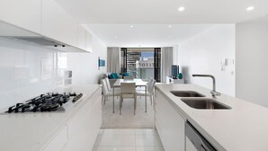 Una cucina moderna con zona pranzo, mobili bianchi e un cartello 'SOFITEL' ben visibile.