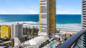 Un hotel di grandi dimensioni con vista sull'oceano, caratterizzato da un design architettonico moderno e una zona piscina.