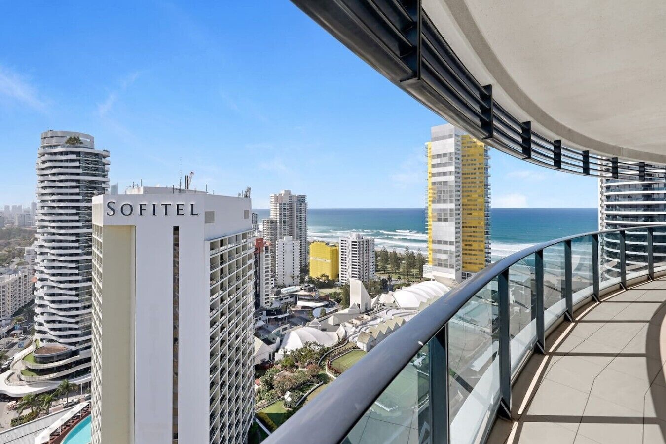 A high-rise hotel with a view of the ocean and other buildings.