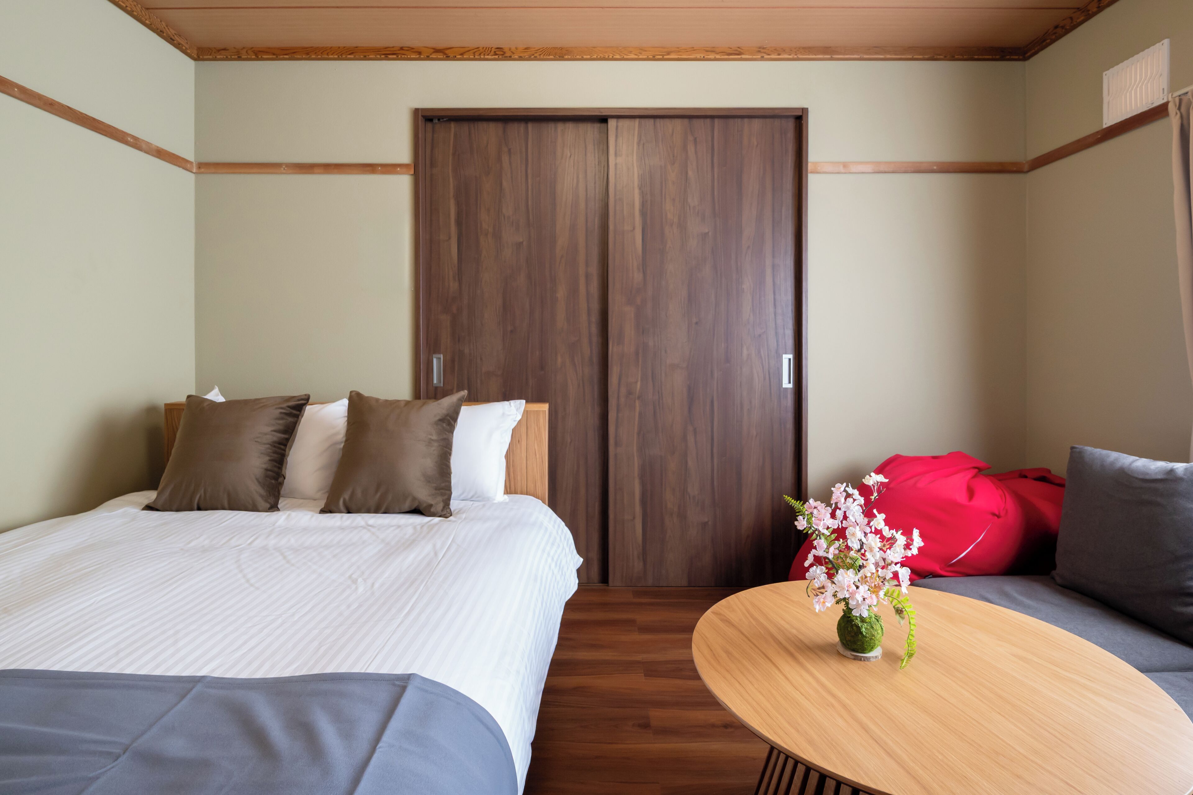 Una habitación de hotel con cama, sofá, mesa de madera y armario.