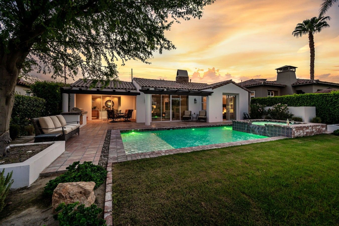 A residential property with a swimming pool, outdoor seating, and a well-maintained garden.