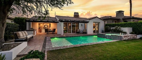 A residential property with a swimming pool, outdoor seating, and a well-maintained garden.