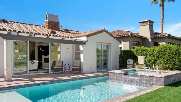A residential property with a swimming pool, patio furniture, and a covered outdoor seating area. - Little Sol at The Palms Golf Club (La Quinta)