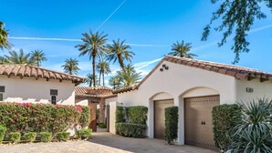 A residential property with a paved driveway, a gated entrance, and a well-maintained garden with various plants. - Little Sol at The Palms Golf Club (La Quinta)