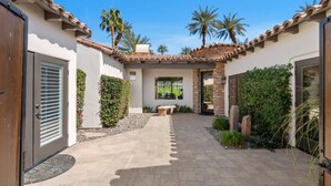 A courtyard with a patio, a bench, and a view of the surrounding landscape. - Little Sol at The Palms Golf Club (La Quinta)