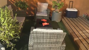 A patio area with wicker furniture, a small table, potted plants, and a wooden bench. - Fabulous 3-bedroom house in enjoyable Ensenada for your getaway (Ensenada)