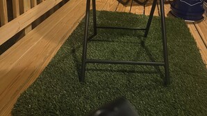 Une terrasse en bois avec une chaise en métal et un tonneau bleu.