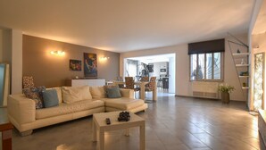Ein Wohnzimmer mit einer Couch, einem Couchtisch und einem Essbereich mit Stühlen und einem Tisch.