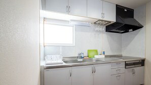 Una cocina moderna con lavavajillas, doble pileta y campana extractora negra.