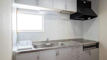 A modern kitchen with a stainless steel sink, a dishwasher, and a black range hood.