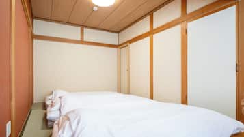 A room with a bed, wooden walls, a ceiling light, and a sliding door.