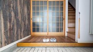 A traditional Japanese room with tatami flooring, a sliding door with glass panels, and a wooden staircase. - Villa Shigin (Sorachi-gun,Nakafurano-cho)