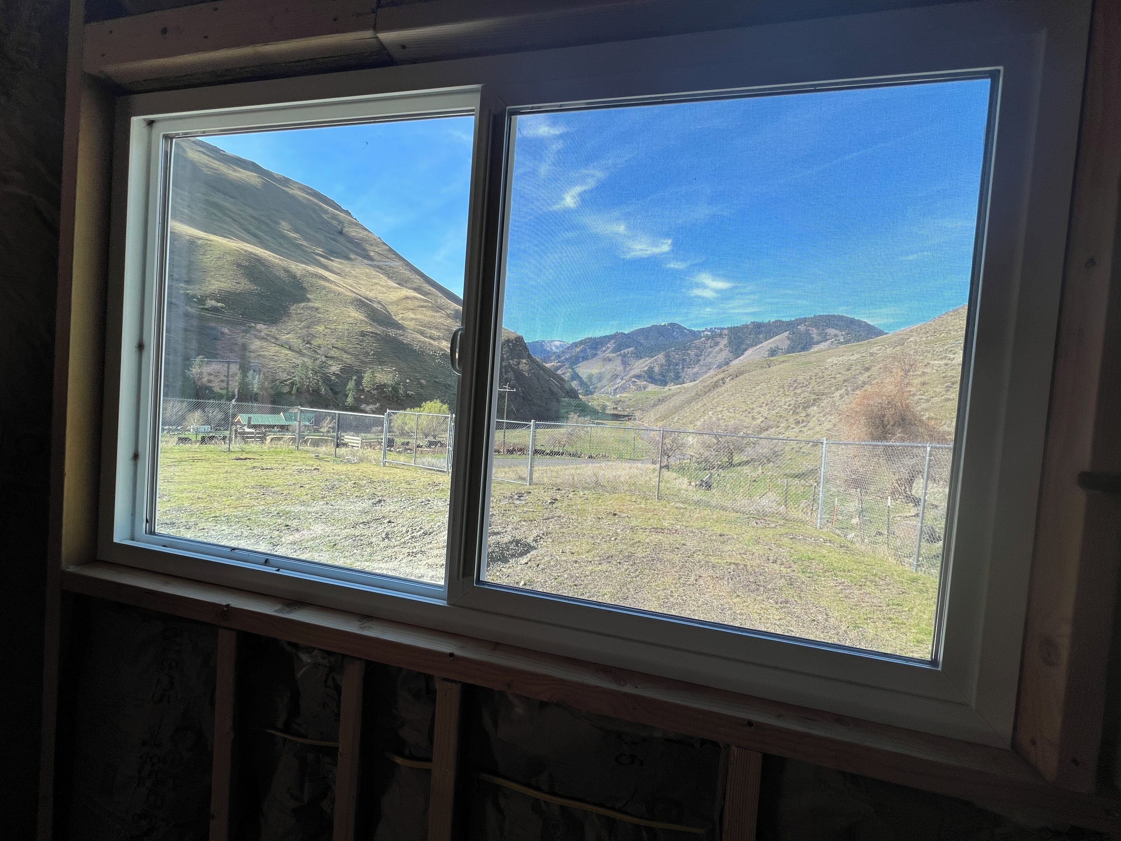 A window with a view of a mountainous landscape.
