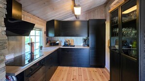 A modern kitchen with dark cabinetry, a wooden countertop, and a built-in refrigerator. - Nice home in Rauland with house a mountain view (Rauland)