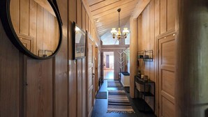 A wooden hallway with a mirror, a chandelier, and a view into another room. - Nice home in Rauland with house a mountain view (Rauland)
