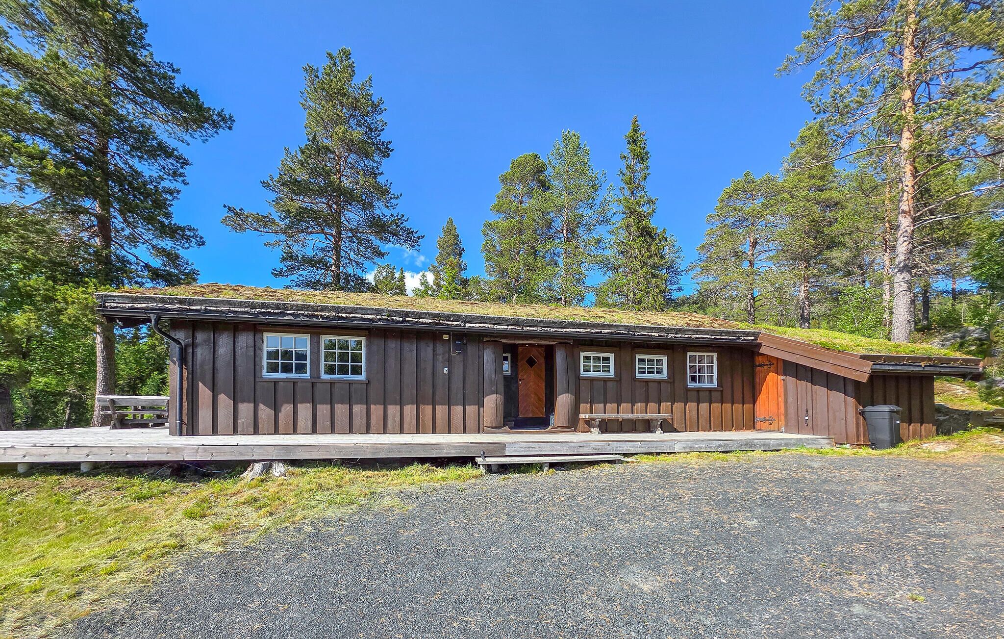 Eine Holzhütte mit Veranda, Tür und Fenstern.