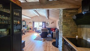 A spacious living area with a stone fireplace, wooden floors, and a cozy seating arrangement. - Nice home in Rauland with house a mountain view (Rauland)