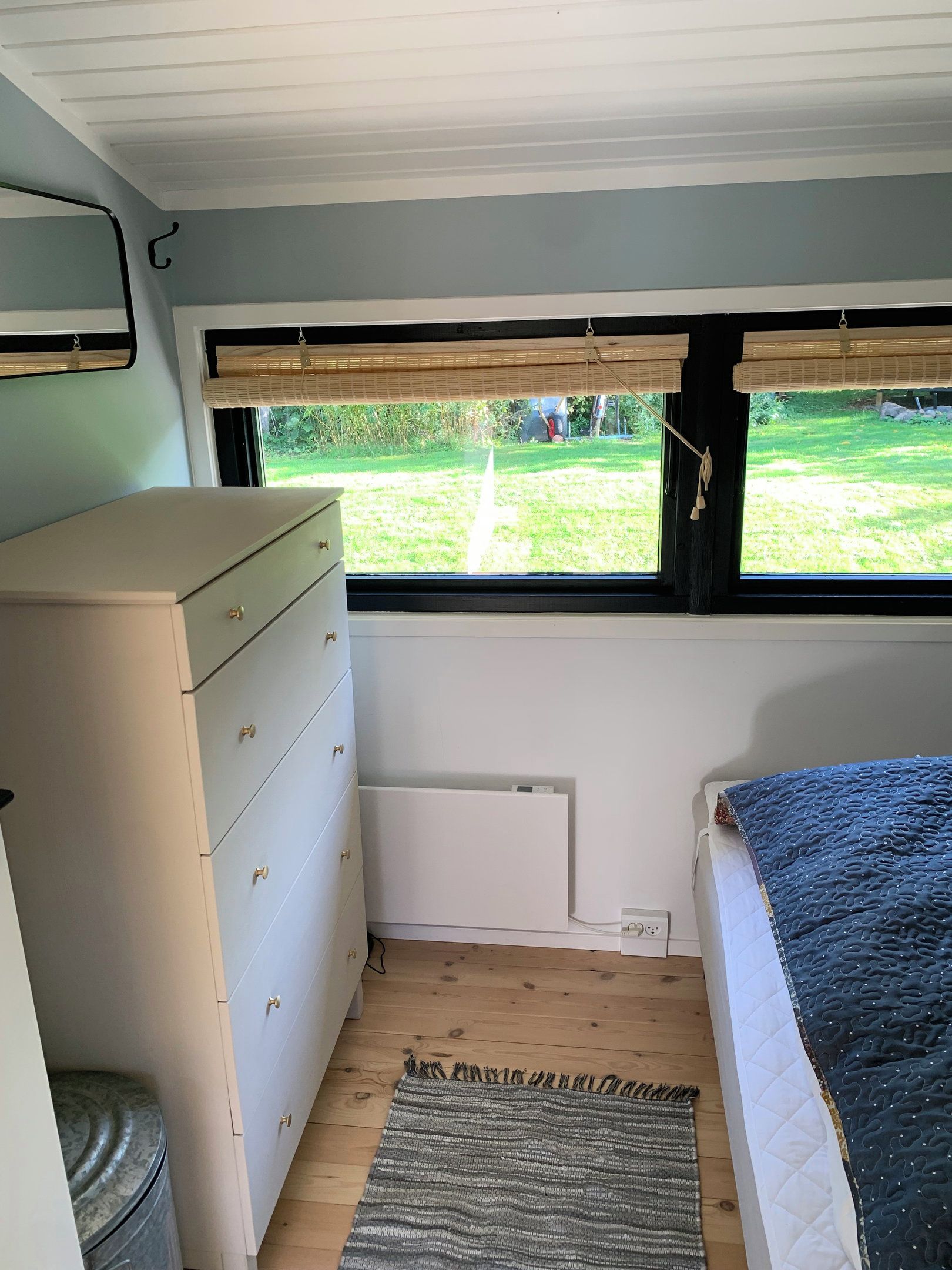 Quarto com janela, cómoda, radiador e cama.