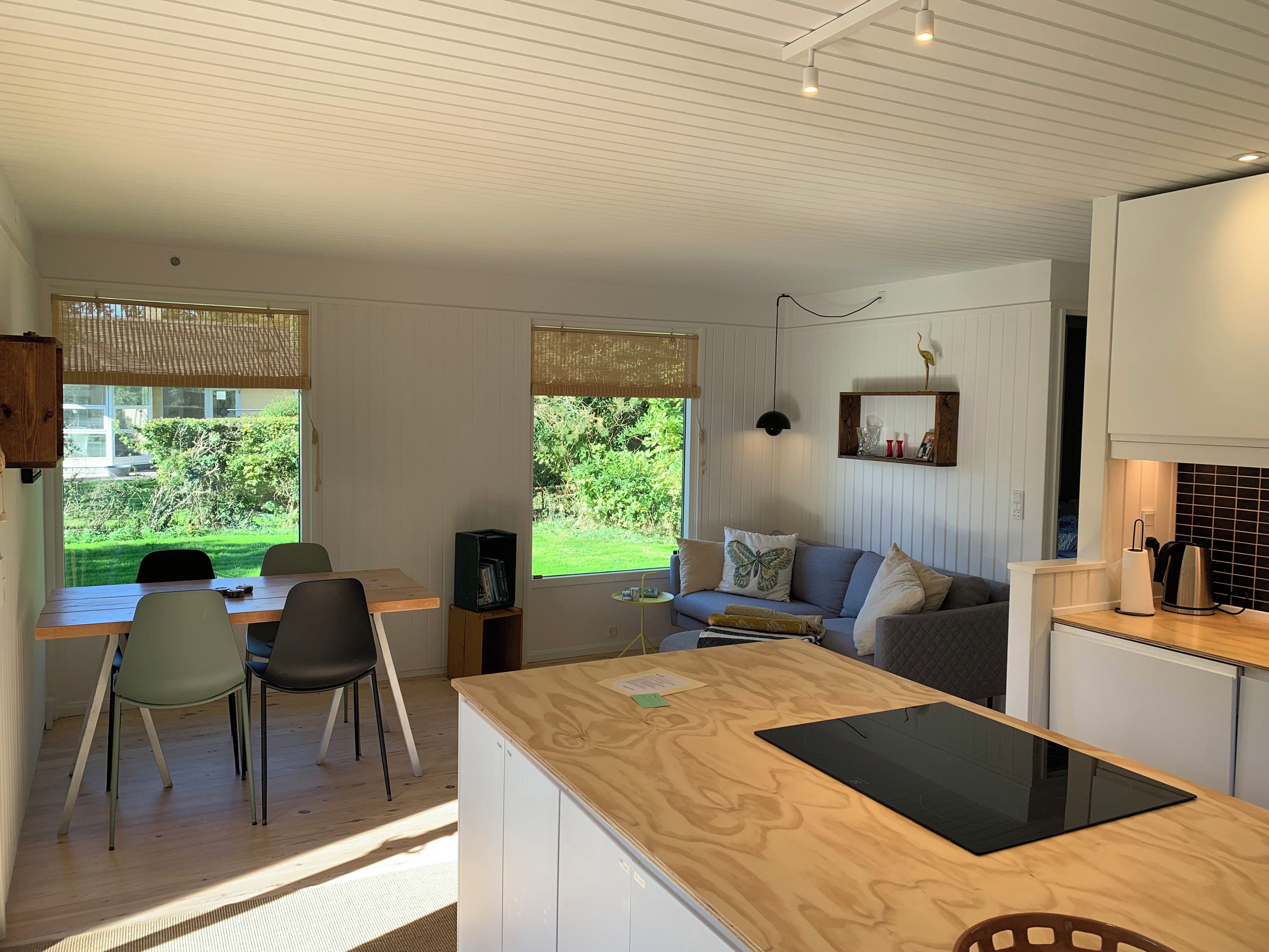 A modern interior with a dining area, sofa, and kitchen.