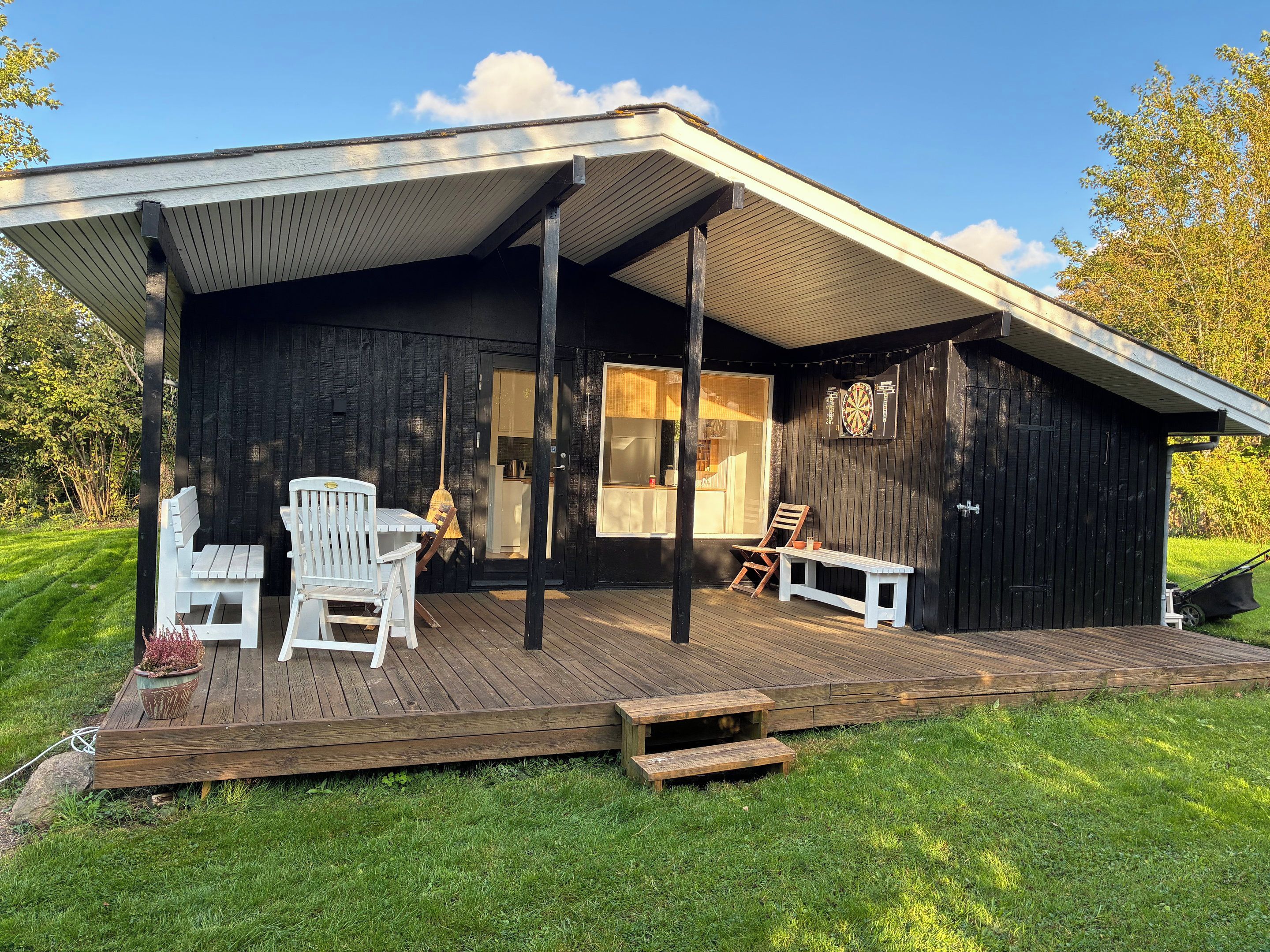 A wooden deck with outdoor seating and a covered area.
