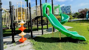 A playground with a green slide and climbing structures.