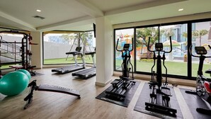 A gym with treadmills, elliptical machines, and exercise balls.