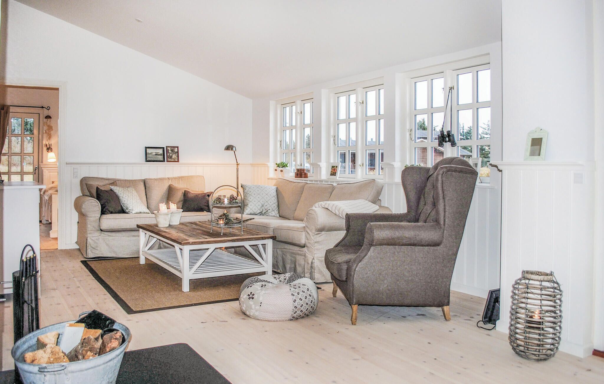 A living room with a sofa, armchair, coffee table, and a fireplace.