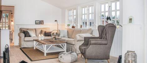 A living room with a sofa, armchair, coffee table, and a fireplace.