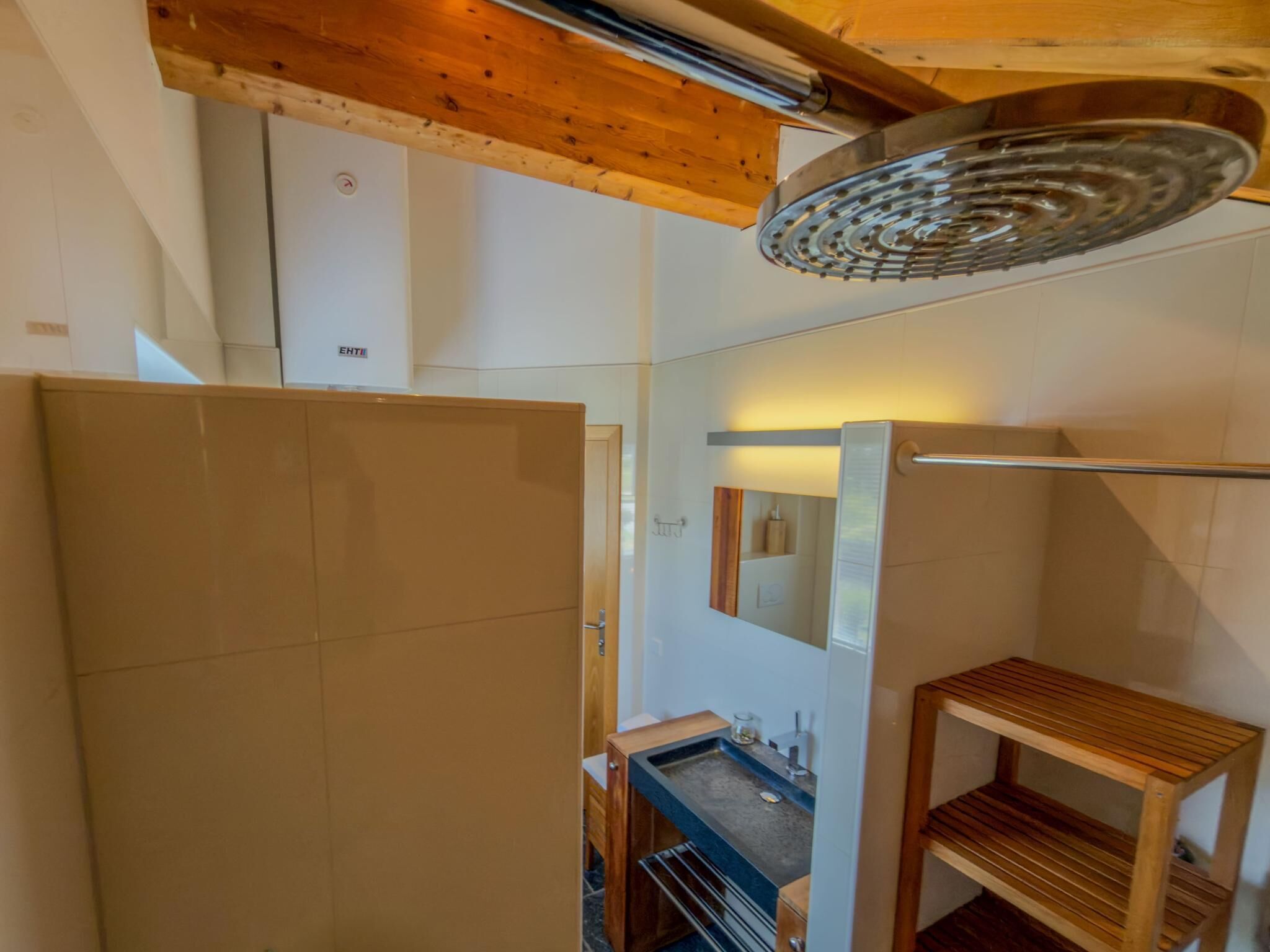 A bathroom with a shower, a sink, and a mirror.