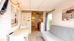 Een compacte leefruimte met een eethoek, kitchenette en een zithoek.