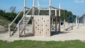 Een houten speelconstructie met een trap en klimelementen.