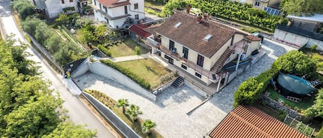 Vista aérea de una zona residencial con casas, una piscina y una carretera.