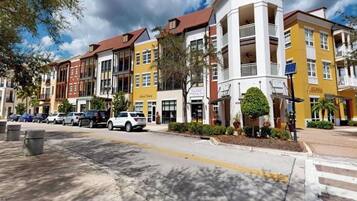 A multi-story hotel with a central courtyard, outdoor seating, and a variety of commercial spaces on the ground floor.