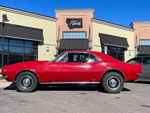 A red vintage car parked in front of a building with a sign that reads '406 Fitness.' - Perfect 3-bedroom house centrally located in the Flathead. (Kalispell)