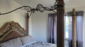 A four-poster bed with a wooden headboard and a metal frame. - Perfect 3-bedroom house centrally located in the Flathead. (Kalispell)