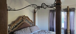 A four-poster bed with a wooden headboard and a metal frame. - Perfect 3-bedroom house centrally located in the Flathead. (Kalispell)