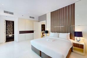 Een moderne hotelkamer met een groot bed, een kledingkast, een badkamer en uitzicht op de stad.