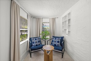 A corner room with two blue sofas, a wooden table, and a potted plant. - West Palm Beach Home (West Palm Beach)