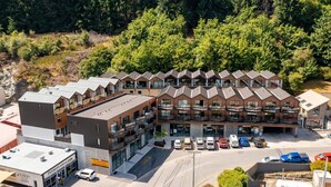Un hotel de varios pisos con estacionamiento y una fila de balcones.