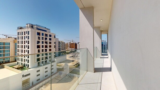 A modern building with a glass balcony overlooking a construction site and other buildings. - Premium Studio l near Museum of Future and Metro (Al Satwa)