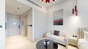 A modern hotel room with a sofa, a small table, a bed, and a painting on the wall. - Premium Studio l near Museum of Future and Metro (Al Satwa)