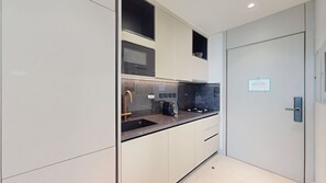 Une cuisine moderne dotée d’un four encastré, d’un évier avec un robinet doré et d’une cuisinière.