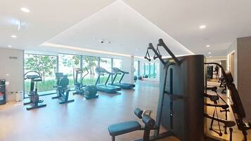A gym with treadmills, elliptical machines, and weightlifting equipment.
