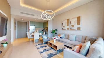 A modern living room with a sofa, coffee table, and dining area.