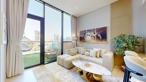 A modern living room with a sectional sofa, a marble coffee table, and a large window with a city view. - Luxe 1 Bed with Private Pool l Tennis Court (JVC)
