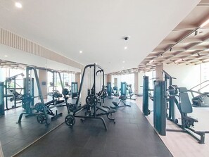 A modern gym with various exercise equipment, large windows, and a clean, spacious layout. - Luxe 1 Bed with Private Pool l Tennis Court (JVC)