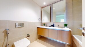 Un baño moderno con inodoro, lavamanos y ducha.