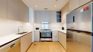 Eine moderne Küche mit Edelstahlgeräten, einem Geschirrspüler und einem eingebauten Backofen.